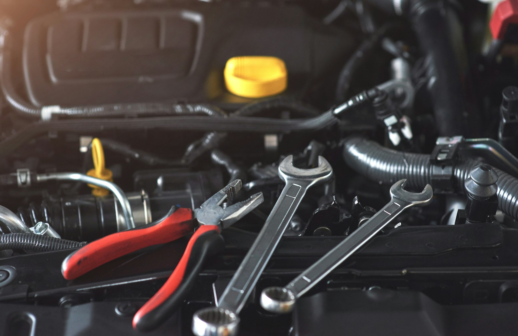 Mechanic hand checking and fixing a broken car in car service garage